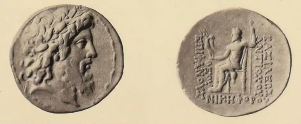 Antike griechische Silber-Tetradrachme in Vorder- und Rückseitenansicht; die Vorderseite zeigt den bärtigen, lorbeerbekränzten Kopf des Zeus nach rechts, die Rückseite Zeus Nikephoros nach links thronend mit Nike und langem Zepter, umgeben von griechischen Königstiteln.