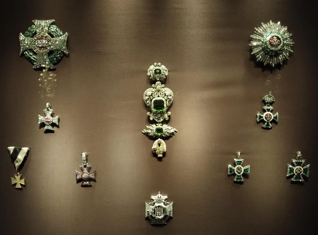 Mid-19th-century imperial jewelry from the Habsburg dynasty, including gem-encrusted crosses and orders, displayed in a museum setting.