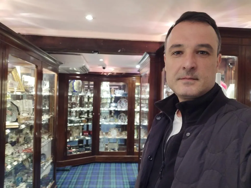 Ein Rundgang durch das Cromwell’s Antique Centre – glänzende Vitrinen voller ausgewählter Antiquitäten unter warmem Licht und rustikalen Holzbalken.