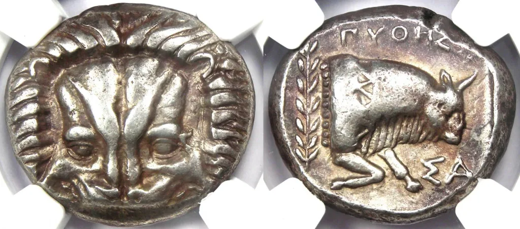 Zweiansicht einer samischen Silber-Tetradrachme in einer Halterung, mit frontalem Löwenskalp auf der Vorderseite und dem Vorderteil eines nach rechts gerichteten Stieres auf der Rückseite, daneben ein Lorbeerzweig und griechische Buchstaben.
