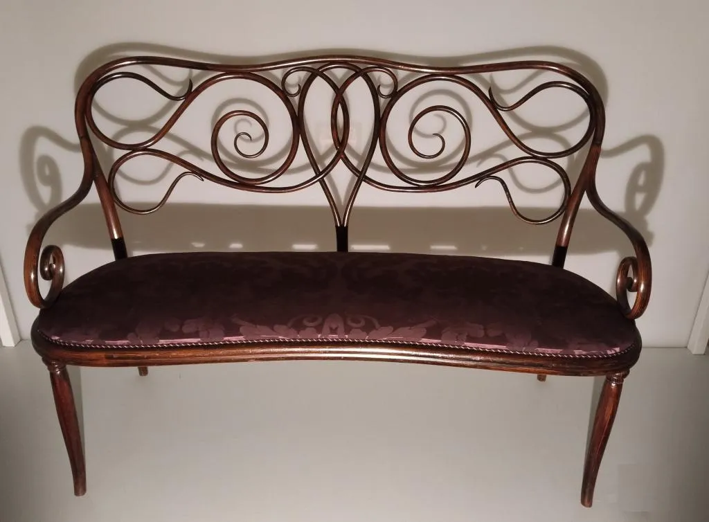 Thonet bentwood settee Model No. 4 with ornate scroll backrest, two-part armrests, rosewood-stained beechwood frame, and renewed damask upholstery. Designed by Michael Thonet c.1850, made by Gebrüder Thonet c.1860.